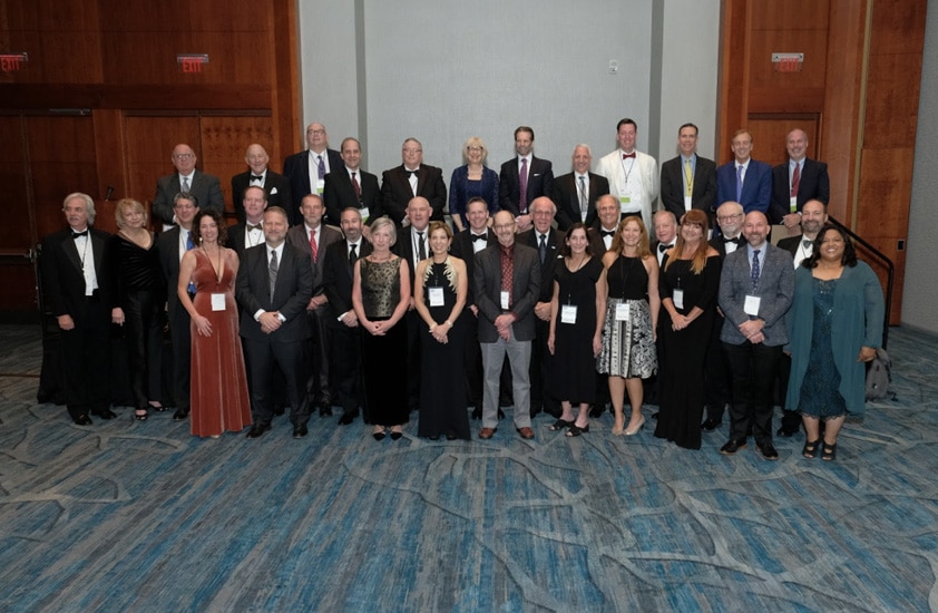 Lots of people standing for a photo in one room
