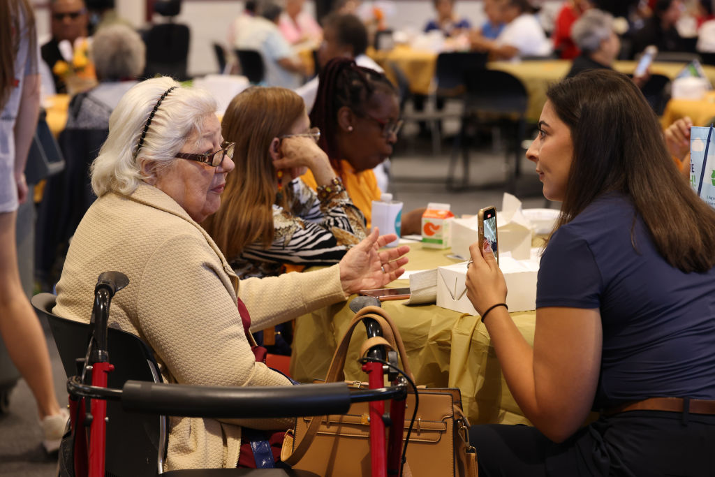 Old woman sitting in wheelchair talking to younger woman
