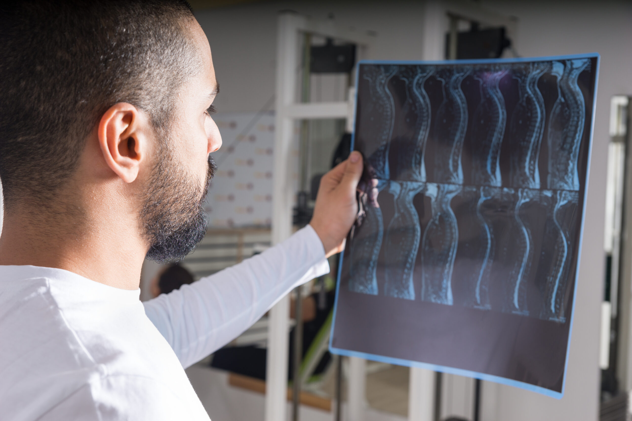 Radiologist,Studying,X-ray,Image,Of,Human,Spine,In,Consulting,Room