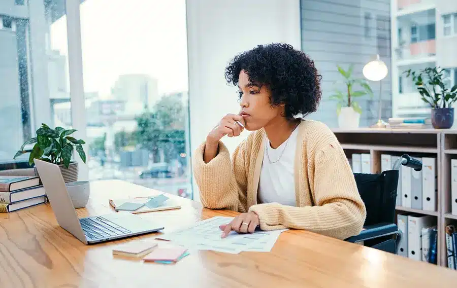 Woman sitting at a desk looking at a laptop