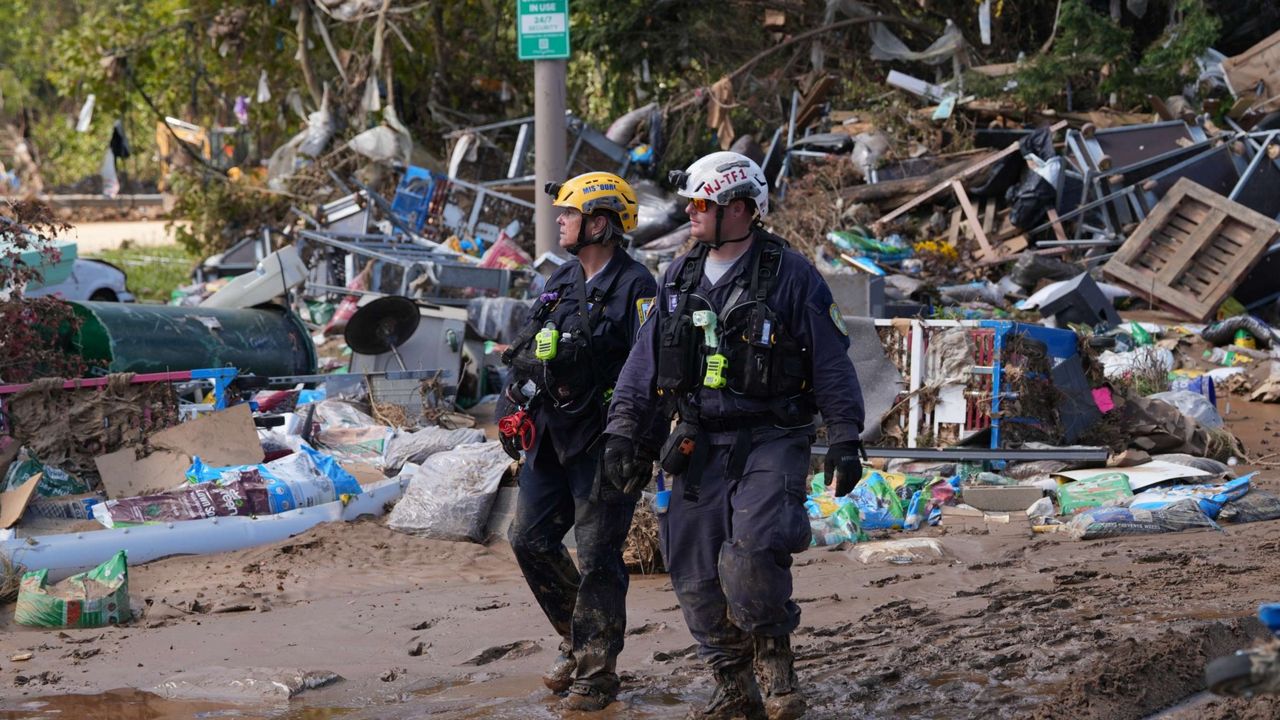 Two rescue officers walking around a destroyed scene