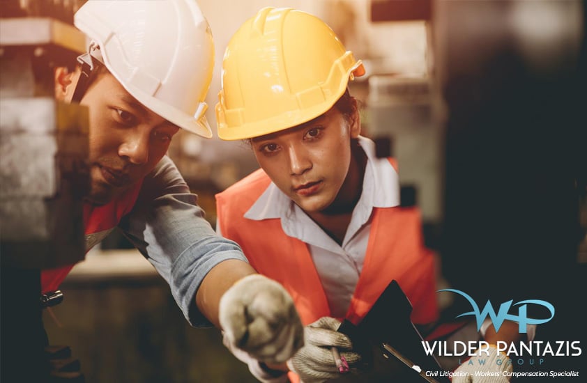 Male and female construction worker pointing at an object
