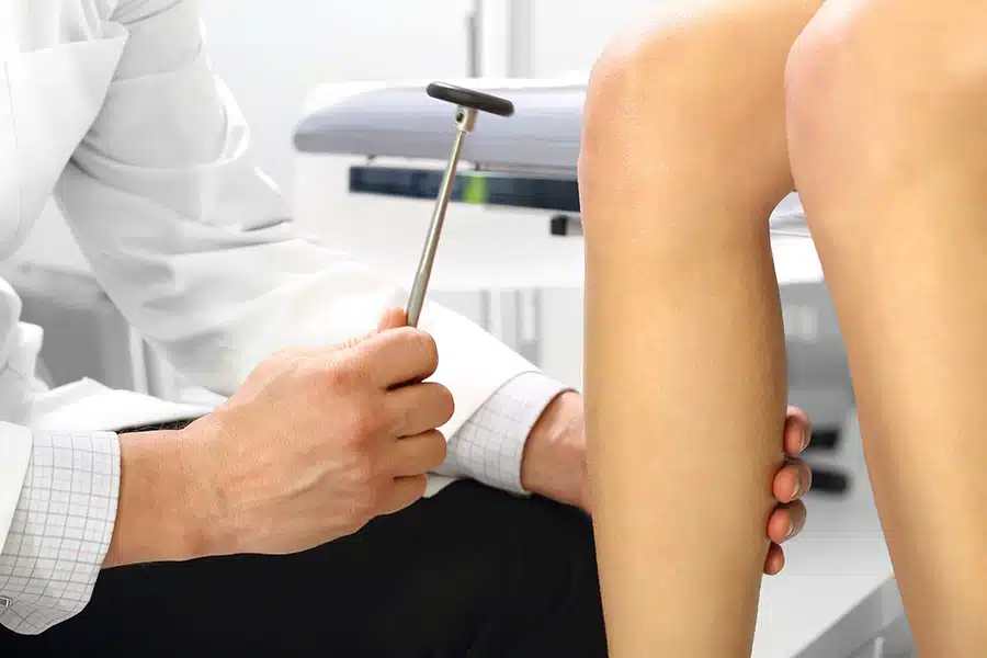 Doctor testing reflexes on a patient